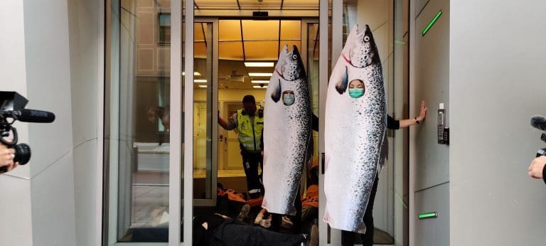 Demonstranter, kledd ut som laks, limte seg fast i departementets lokaler